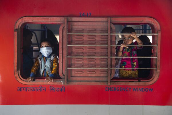 Мальчики смотрят в окно поезда на железнодорожной станции в Гаухати, Индия - Sputnik Абхазия