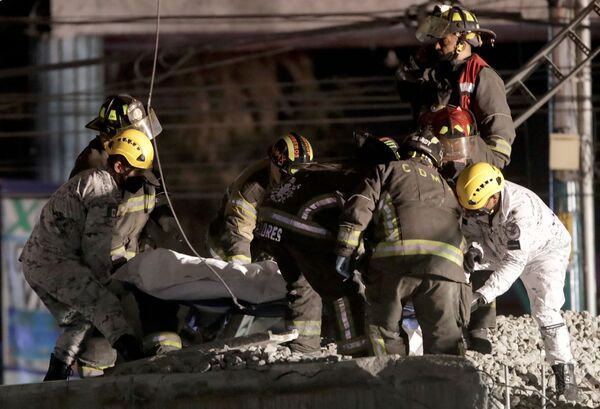 Спасатели с телом погибшего от обрушения метромоста на станции Оливос в Мехико, Мексика  - Sputnik Абхазия