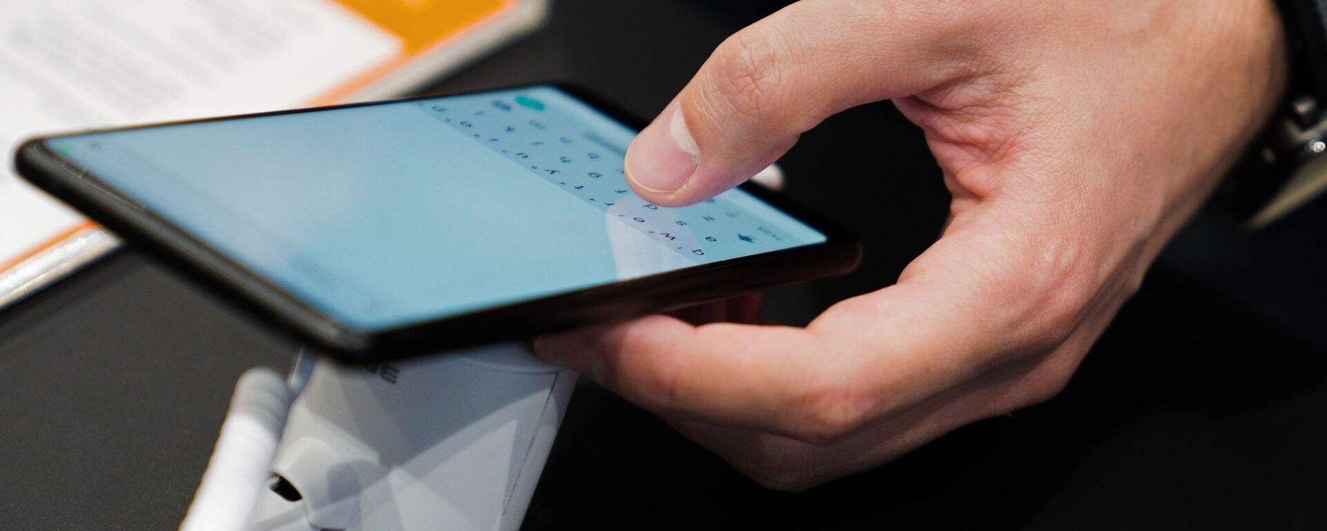 Посетитель осматривает смартфон в магазине Xiaomi на Тверской улице в Москве. Компания Xiaomi открыла новый официальный круглосуточный магазин в Москве. - Sputnik Аҧсны, 1920, 21.03.2026