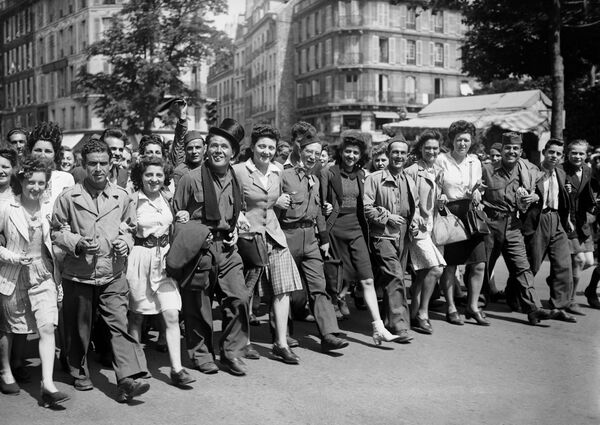 Мирные жители, партизаны и солдаты маршируют по улицам Парижа в день окончания боевых действий Второй Мировой войны - Sputnik Абхазия