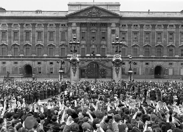 Огромная толпа, собравшаяся перед Букингемским дворцом в Лондоне в День Победы 8 мая 1945 года, приветствует королевскую семью - Sputnik Абхазия