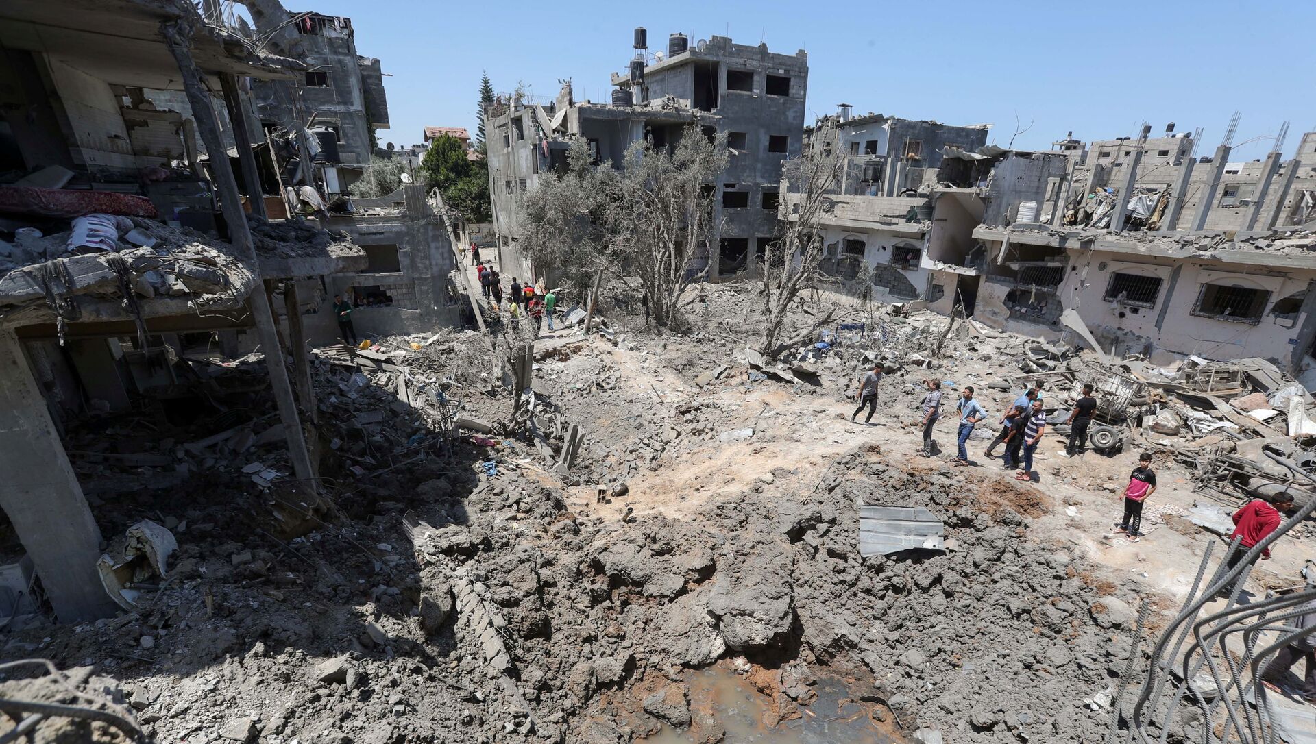 Палестинцы собираются на месте разрушенных домов после израильских авиационных и артиллерийских ударов в секторе Газа - Sputnik Абхазия, 1920, 17.05.2021