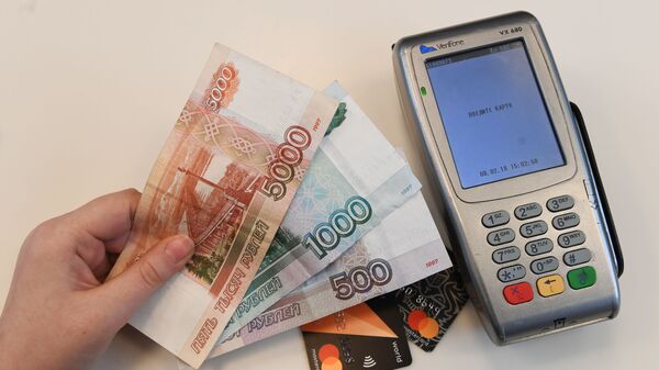 Терминал оплаты банковскими картами и денежные купюры. - Sputnik Абхазия