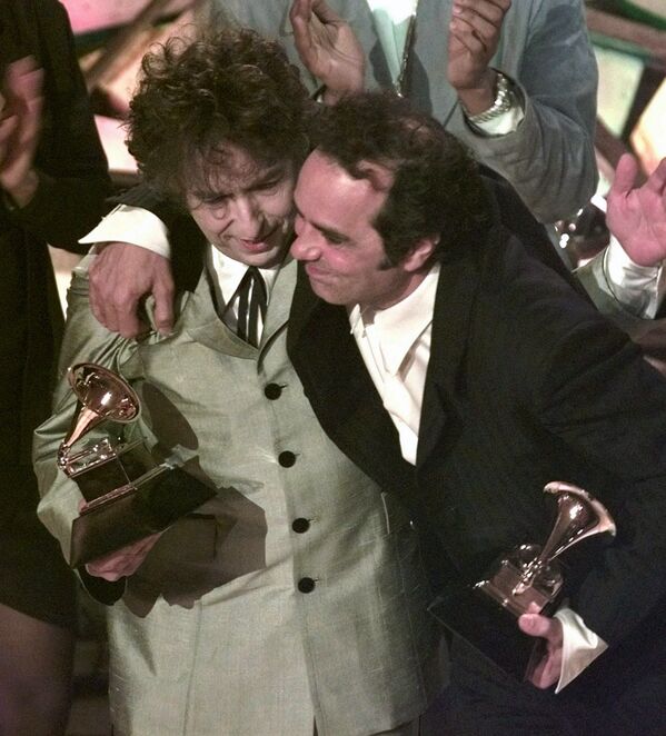 Боб Дилан (слева) и его продюсер Дэниел Лануа обнимаются после того, как певец выиграл альбом года на 40-й ежегодной премии «Грэмми» в Нью-Йорке - Sputnik Абхазия