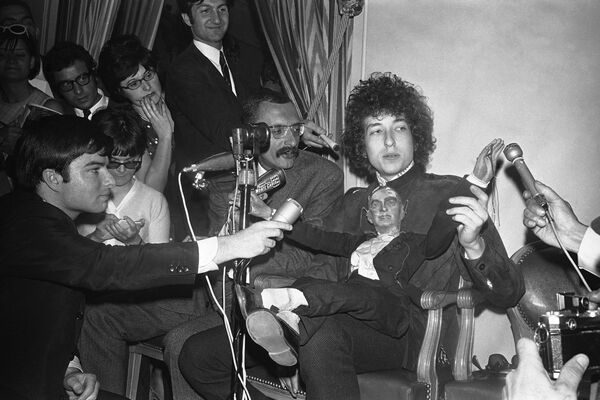 Американский фолк-певец Боб Дилан сидит с марионеткой перед журналистами во время пресс-конференции в отеле George V в Париже, Франция - Sputnik Абхазия