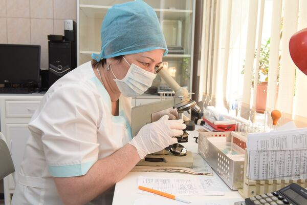 Манана Квеквескири за микроскопом в лаборатории Республиканской больницы. - Sputnik Абхазия