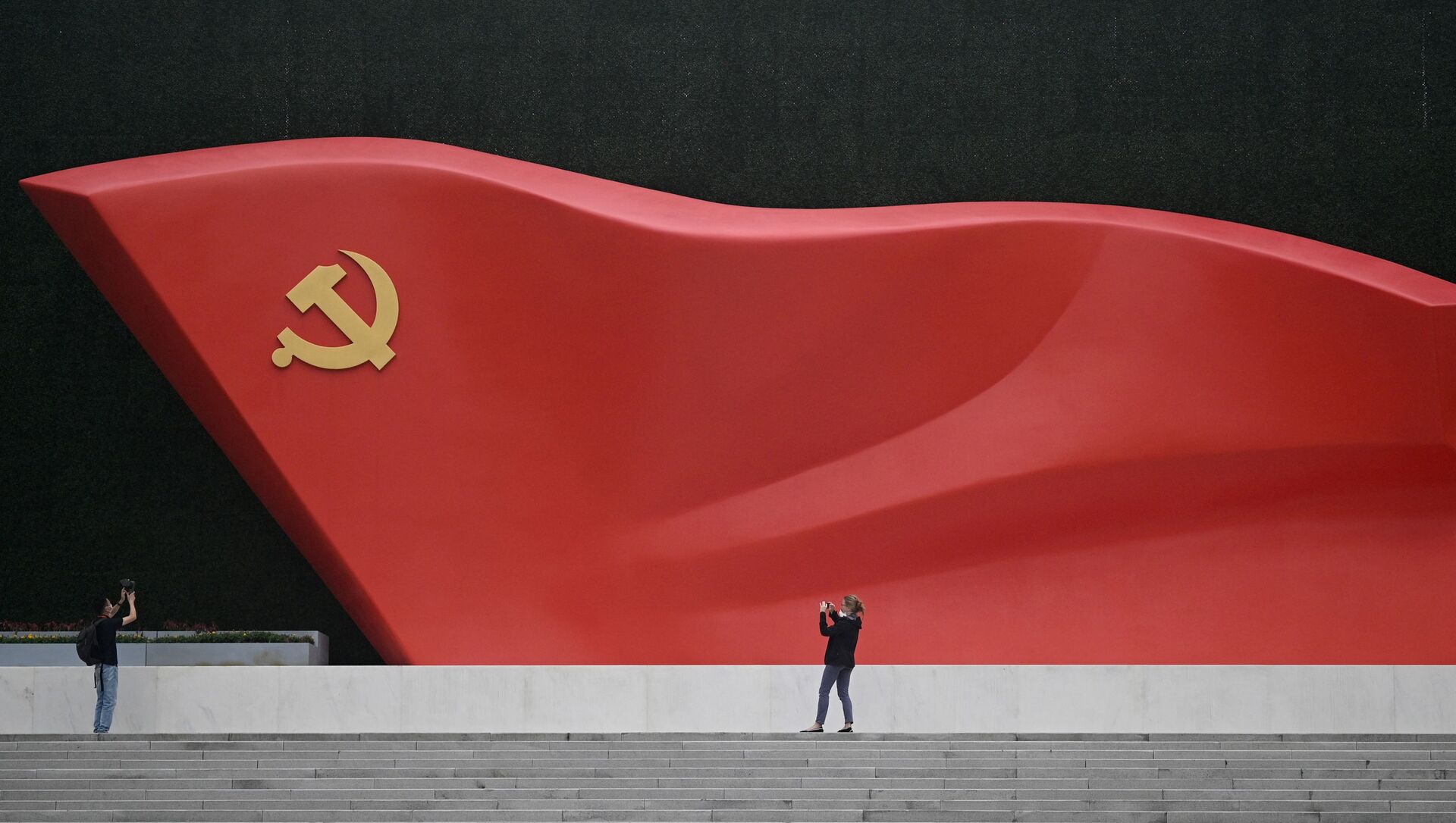 Журналисты фотографируют скульптуру национального флага во время посещения Музея Коммунистической партии Китая возле национального стадиона «Птичье гнездо» в Пекине - Sputnik Абхазия, 1920, 27.06.2021