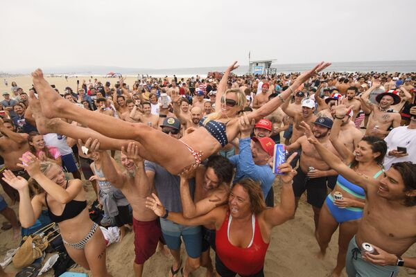 Люди качают неоднократную чемпионку по триатлону Энни Сиврайт-Ньютон после победы в 47-м соревновании Hermosa Beach Ironman. - Sputnik Абхазия
