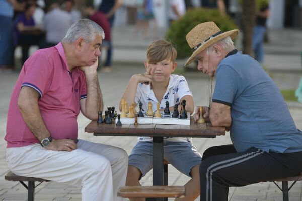 Мужчины и мальчик играют в шахматы на &quot;Брехаловке&quot; - Sputnik Абхазия