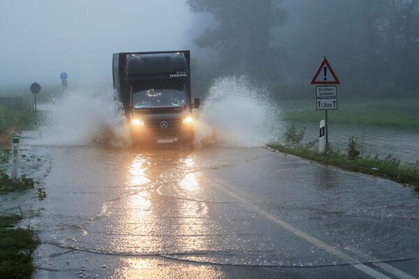 Автомобиль едет по дороге, пострадавшей от наводнения в Германии. - Sputnik Абхазия