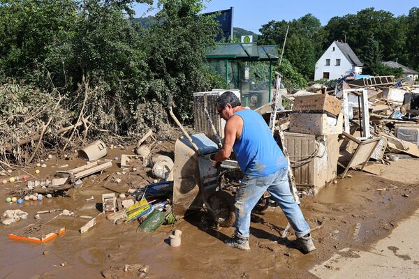 Мужчина выгружает щебень после наводнения в Германии  - Sputnik Абхазия