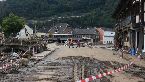 Спасатели переходят грязную улицу, а среди моста и береговой линии реки Ар в городе Альтенар, земля Рейнланд-Пфальц, западная Германия - Sputnik Абхазия