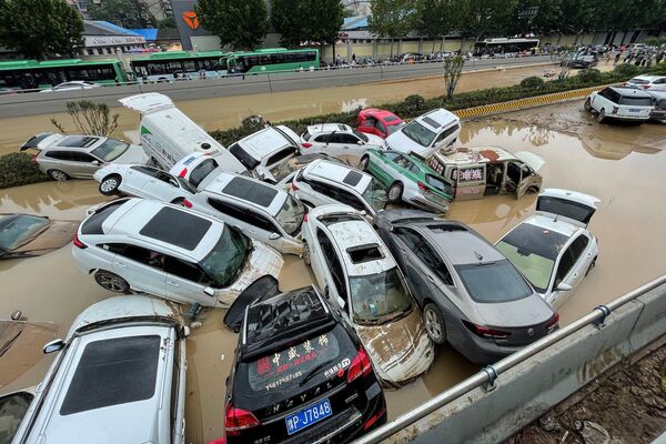 Автомобили стоят в паводковых водах после проливных дождей, обрушившихся на город Чжэнчжоу в центральной китайской провинции Хэнань. - Sputnik Абхазия