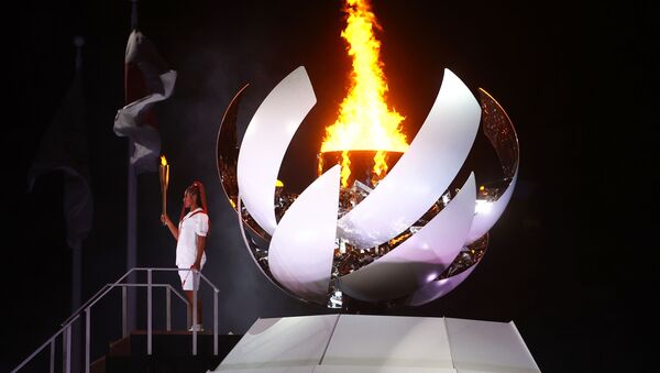 Наоми Осака из Японии держит олимпийский факел после зажжения олимпийского котла на церемонии открытия  - Sputnik Абхазия