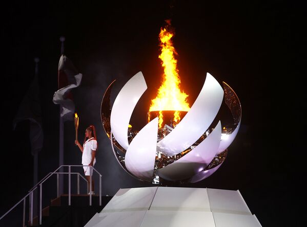 Наоми Осака из Японии держит олимпийский факел после зажжения олимпийского котла на церемонии открытия. - Sputnik Абхазия