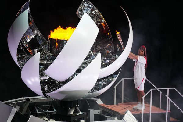 Теннисистка Наоми Осака зажигает олимпийский огонь на церемонии открытия XXXII летних Олимпийских игр в Токио. - Sputnik Абхазия