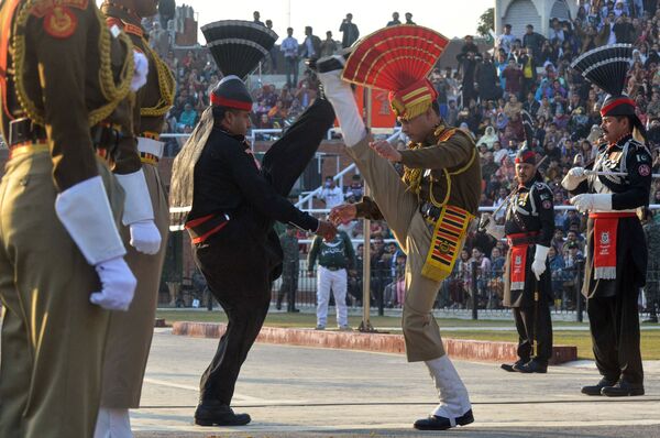 Индийские пограничники в коричневой форме и пакистанские рейнджеры в черной форме выступают во время церемонии  на индийско-пакистанском пограничном посту Вагах - Sputnik Абхазия