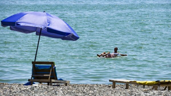 Мужчина купается на круге в море  - Sputnik Абхазия