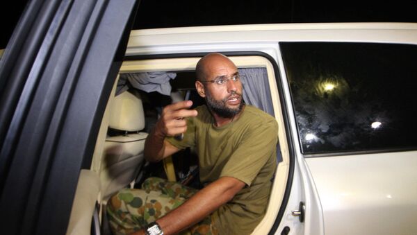 На этой файловой фотографии, сделанной 23 августа 2011 года, изображен Саиф аль-Ислам, сын покойного ливийского диктатора Моамера Каддафи, жестикулирующий, когда он появляется перед сторонниками и журналистами в жилом комплексе своего отца в столице Ливии Триполи в начале часы. - Саиф аль-Ислам Каддафи, которого когда-то считали преемником своего отца, не видел и не слышал публично с тех пор, как десять лет назад он был схвачен в ливийской пустыне. Он разговаривал с международными СМИ и говорит, что хочет стать президентом Ливии. - Sputnik Абхазия