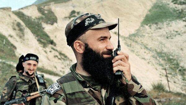 Чеченский полевой командир Шамиль Басаев рассказывает о позициях повстанцев в горах Ботлихского района, недалеко от села Ансалта, во время рейда в Дагестане, на фото из архива в среду, 11 августа 1999 года. - Sputnik Абхазия