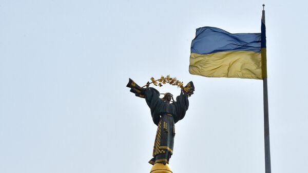 Украинский флаг развевается перед Монументом Независимости в столице Украины Киеве 29 марта 2019 года в преддверии президентских выборов 31 марта - Sputnik Абхазия