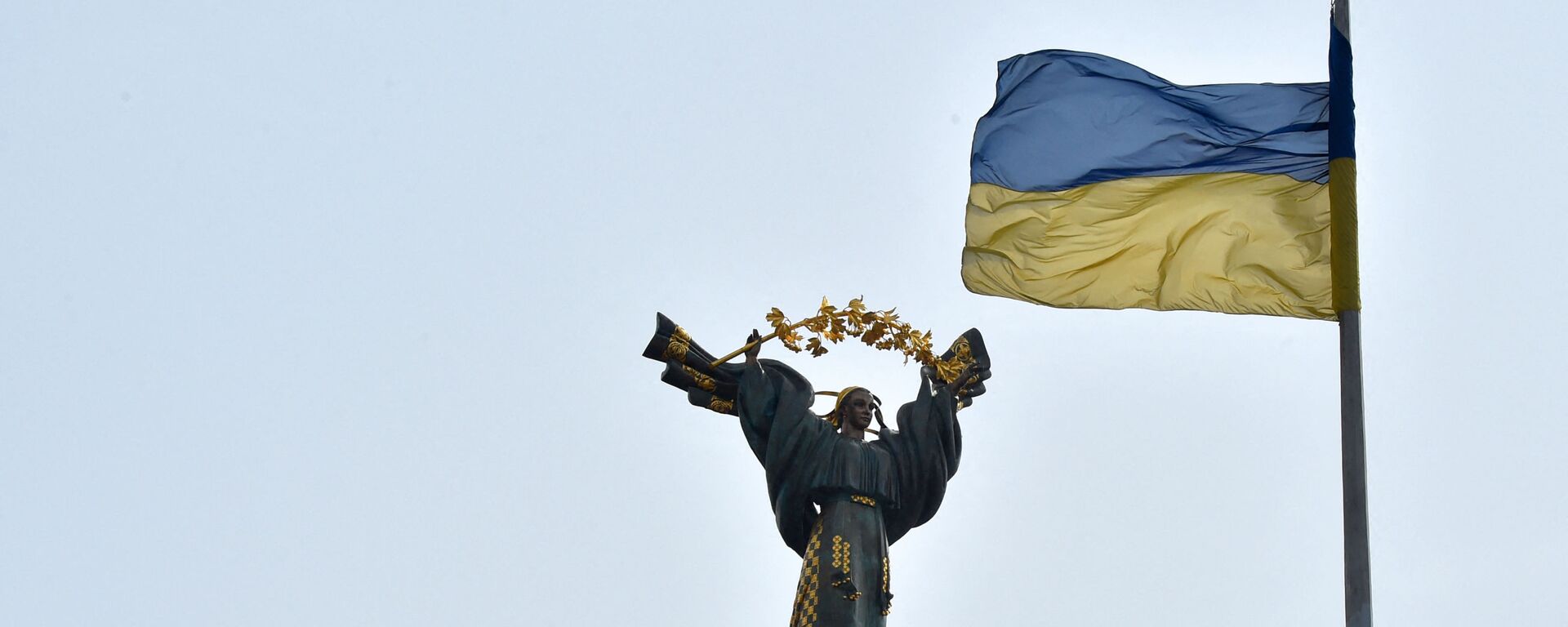 Украинский флаг развевается перед Монументом Независимости в столице Украины Киеве 29 марта 2019 года в преддверии президентских выборов 31 марта - Sputnik Абхазия, 1920, 04.04.2022