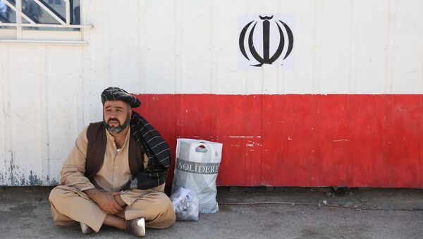 Афганец сидит на пограничном переходе Даукарун между Ираном и Афганистаном - Sputnik Абхазия