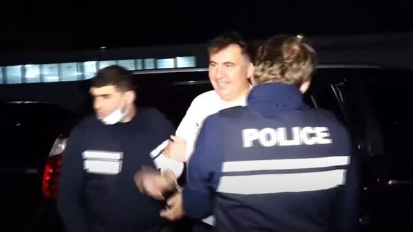 Улыбающийся Саакашвили в руках грузинской полиции - Sputnik Абхазия