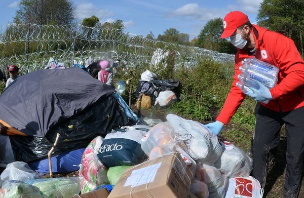 Активисты Белорусского Красного Креста оставляют гуманитарную помощь в лагере беженцев из Афганистана на белорусско-польской границе. - Sputnik Абхазия