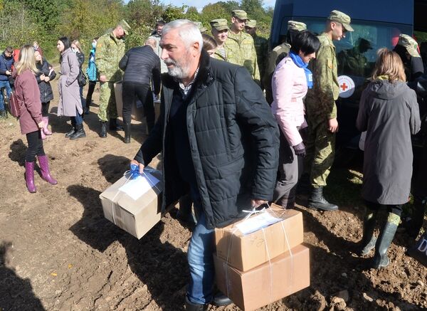 Депутат белорусского парламента Тенгиз Думбадзе несет коробки с гуманитарной помощью для беженцев из Афганистана, застрявших на белорусско-польской границе возле деревни Уснар-Дольное. - Sputnik Абхазия