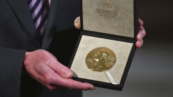 Чарльз М. Райс держит свою Нобелевскую медаль по физиологии и медицине во время церемонии во вторник, 8 декабря 2020 года, в Нью-Йорке. - Sputnik Аҧсны
