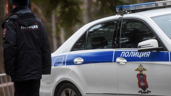 Сотрудник полиции возле служебного автомобиля. - Sputnik Абхазия