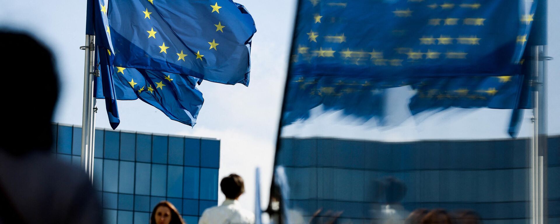 Люди идут перед флагом Евросоюза в районе штаб-квартиры ЕС в Брюсселе 23 сентября 2021 г. - Sputnik Абхазия, 1920, 04.03.2022