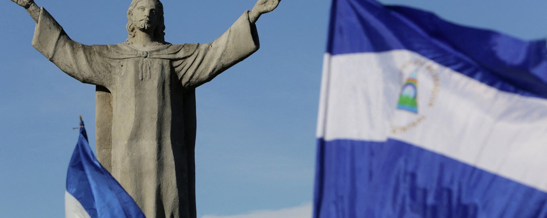 Национальные флаги Никарагуа развеваются возле монумента Христос-Царь в Манагуа во время антиправительственного марша под названием Здесь нет ничего нормального - Sputnik Аҧсны, 1920, 22.11.2021