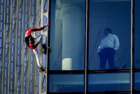Французский городской альпинист Ален Робер поднимается на высотное здание Skyper в центре Франкфурта. - Sputnik Абхазия