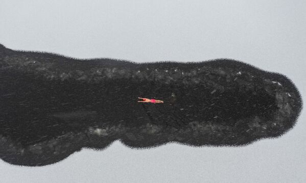 Любитель зимнего плавания в озере во время снегопада в парке в Шэньяне, в провинции Ляонин на северо-востоке Китая. - Sputnik Абхазия