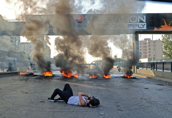 Ливанский демонстрант лежит на улице во время акции протеста в Бейруте. - Sputnik Абхазия