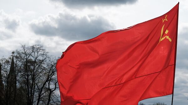 Мужчина с флагом Союза Советских Социалистических Республик на Манежной площади в Москве. - Sputnik Аҧсны