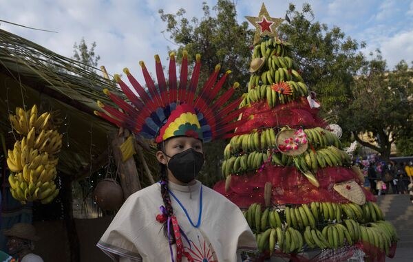 Танцор рядом с рождественской банановой елкой на площади Мурильо в Боливии во время церемонии зажжения елки. - Sputnik Абхазия