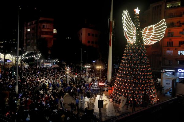 Люди собрались посмотреть процесс освещения гигантской рождественской елки в  начале рождественских праздников на площади Сассин в одном из районов Бейрута, Ливан. - Sputnik Абхазия