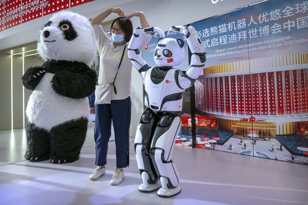 Посетительница фотографируется с роботом-пандой на стенде китайского производителя UBTech на Всемирной конференции по робототехнике в Пекине, 11 сентября 2021 года. - Sputnik Абхазия