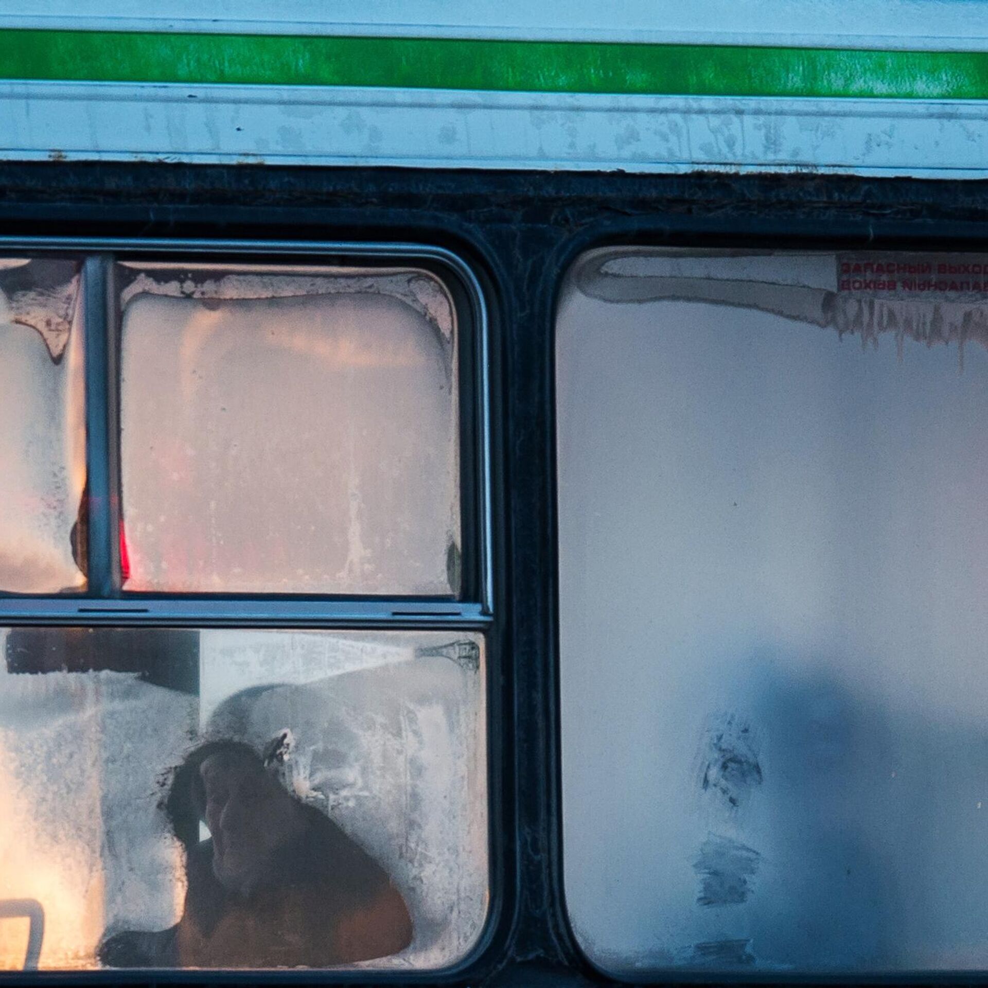 В окне автобуса поплыл. Люди ждут автобус зимой. Мороз на стекле папа.
