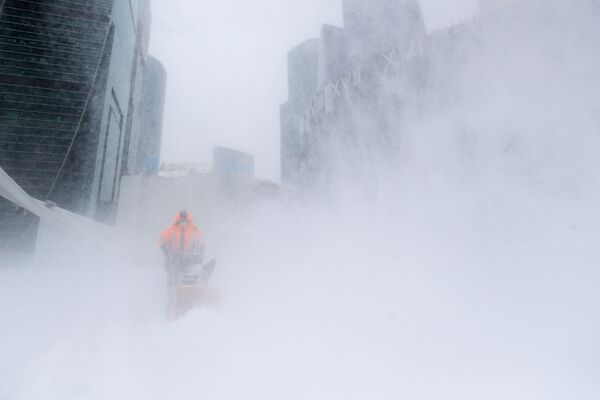 Сотрудник коммунальной службы убирает снег с площади у делового центра &quot;Москва-сити&quot;. - Sputnik Абхазия