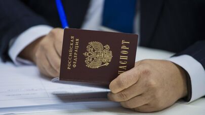 Сотрудник избирательной комиссии на участке №8159 в посольстве России в Киргизии вносит сведения из паспорта гражданина РФ, пришедшего проголосовать на выборах депутатов Государственной Думы РФ, в список избирателей.