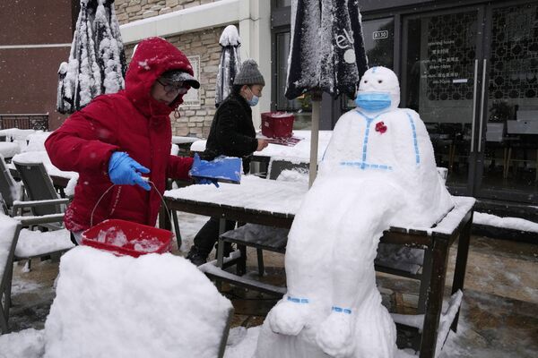 Работники ресторане лепят снеговика в форме медицинского работника в защитном костюме и маске в Пекине, Китай. - Sputnik Абхазия