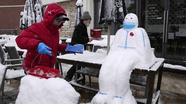Работники ресторане лепят снеговика в форме медицинского работника в защитном костюме и маске в Пекине, Китай - Sputnik Абхазия