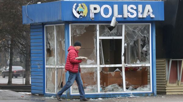 Мужчина проходит мимо полицейского участка, разрушенного во время беспорядков в Алматы - Sputnik Абхазия
