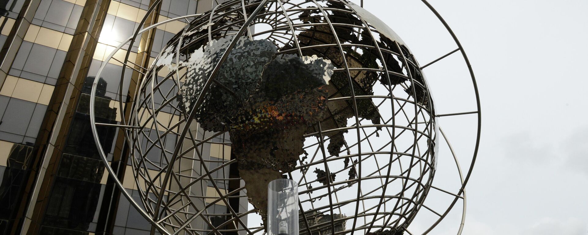 Скульптура глобуса на площади Коламбус-серкл в Нью-Йорке. На дальнем плане - международная гостиница и башня Трампа - Sputnik Абхазия, 1920, 20.01.2022