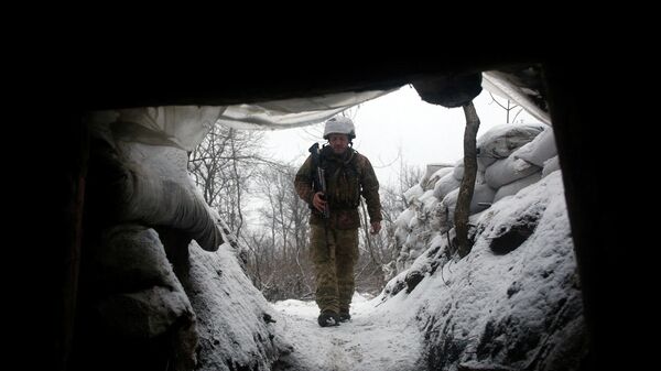 Военнослужащий ВСУ идет по заснеженной траншеи на линии фронта с пророссийскими сепаратистами возле села Золотое на востоке Луганской области - Sputnik Абхазия