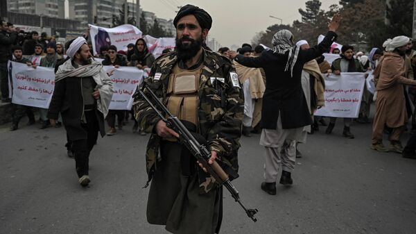 Боец Талибана сопровождает людей во время демонстрации осуждения недавней акции протеста афганских активистов за права женщин в Кабуле 21 января 2022 года. - Sputnik Абхазия